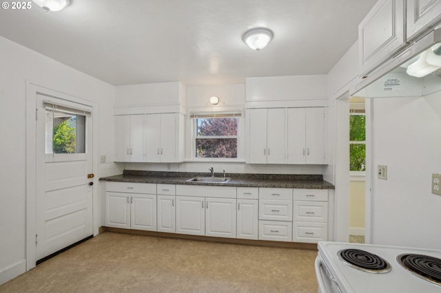 kitchen featuring a sink, electric range, a healthy amount of sunlight, and white cabinetry