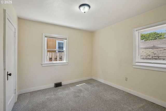 empty room featuring carpet floors and baseboards