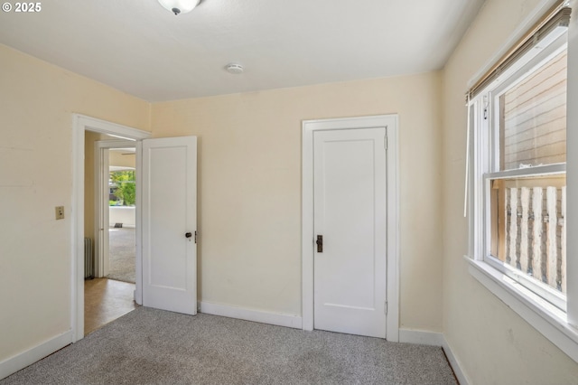 unfurnished bedroom with carpet floors and baseboards