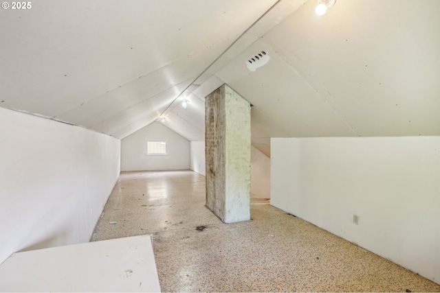bonus room with speckled floor and lofted ceiling