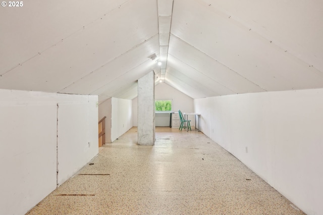 bonus room with lofted ceiling and light speckled floor