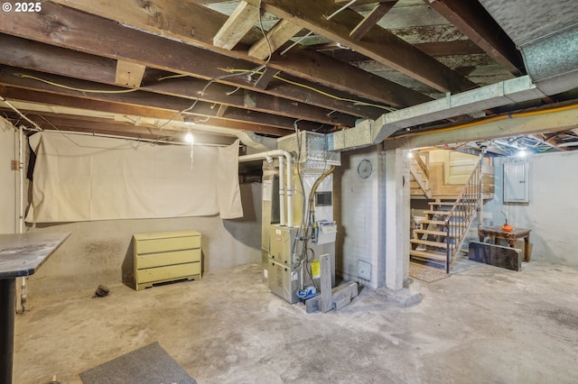 unfinished below grade area featuring heating unit, electric panel, and stairway