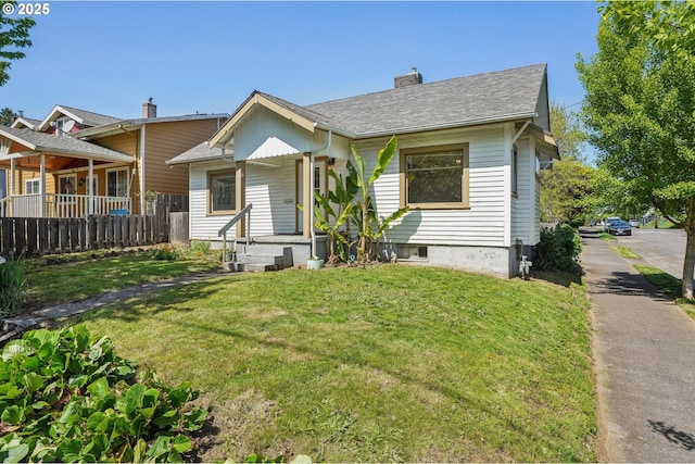 bungalow-style home featuring covered porch, a chimney, roof with shingles, a front yard, and fence