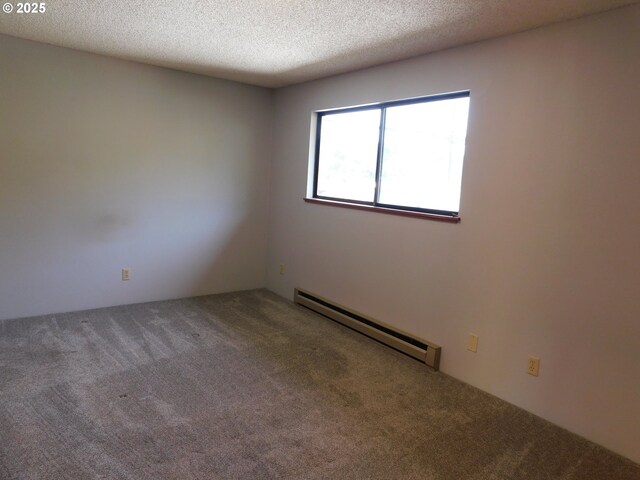 carpeted empty room featuring a baseboard heating unit and a textured ceiling