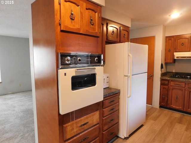 kitchen featuring white appliances and light hardwood / wood-style flooring