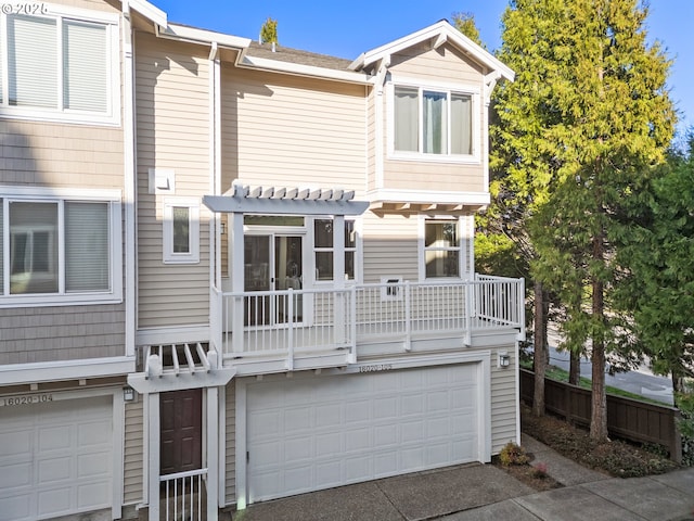 multi unit property featuring an attached garage, a pergola, and driveway