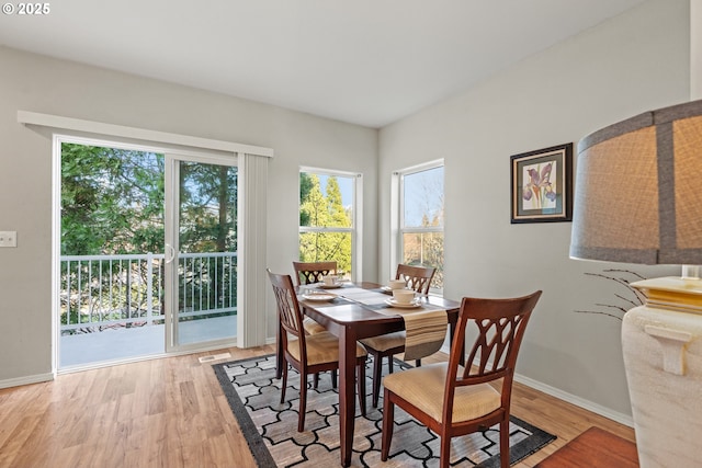 dining room with light wood-style flooring, visible vents, and baseboards