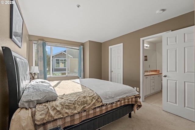 bedroom featuring ensuite bathroom and light carpet