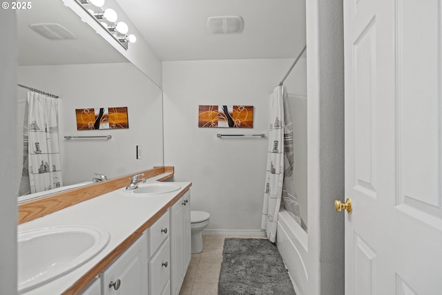 bathroom with tile patterned flooring, double vanity, toilet, and a sink