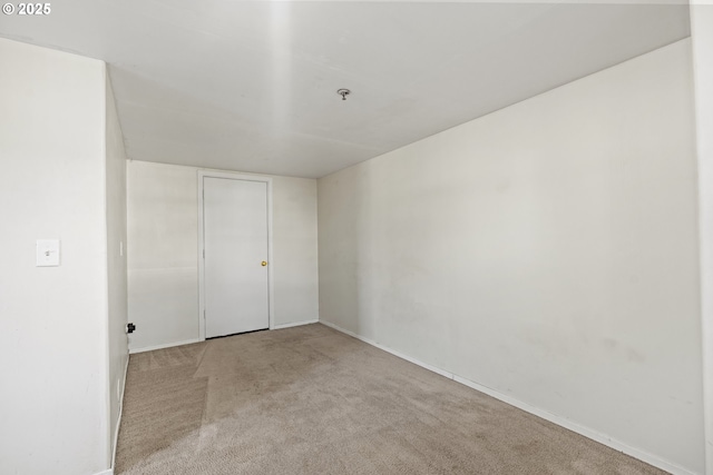 carpeted spare room featuring baseboards