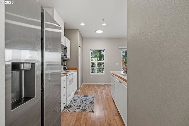 kitchen featuring white cabinets, white appliances, light countertops, and light wood-style floors