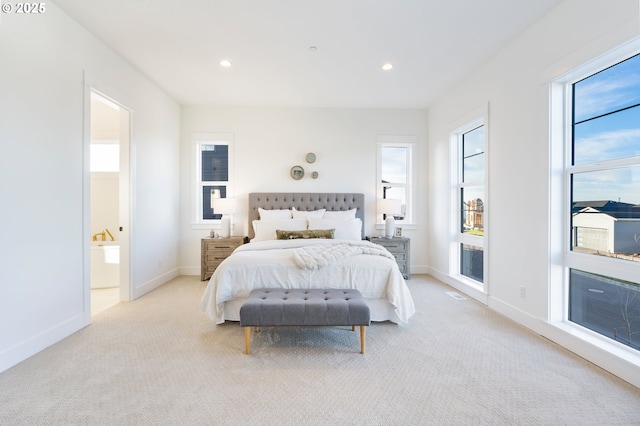 bedroom featuring light colored carpet, ensuite bathroom, and access to outside