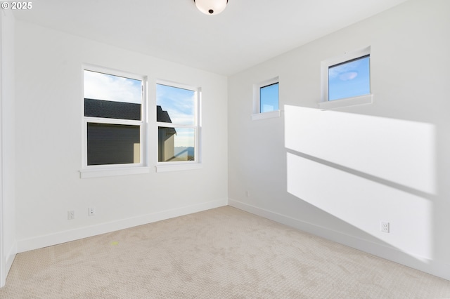 unfurnished room featuring light carpet