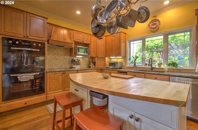 17130 Eastwood Ln, Brookings, OR 97415 - kitchen with butcher block counters, a sink, appliances with stainless steel finishes, custom range hood, and ornamental molding