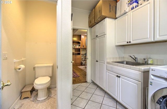 17130 Eastwood Ln, Brookings, OR 97415 - washroom featuring washer / clothes dryer, a sink, ornamental molding, light tile patterned floors, and baseboards