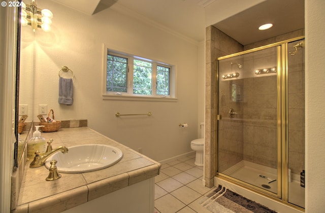 bathroom featuring vanity, a shower with door, tile patterned floors, crown molding, and toilet