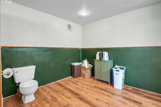 bathroom featuring wood finished floors and toilet