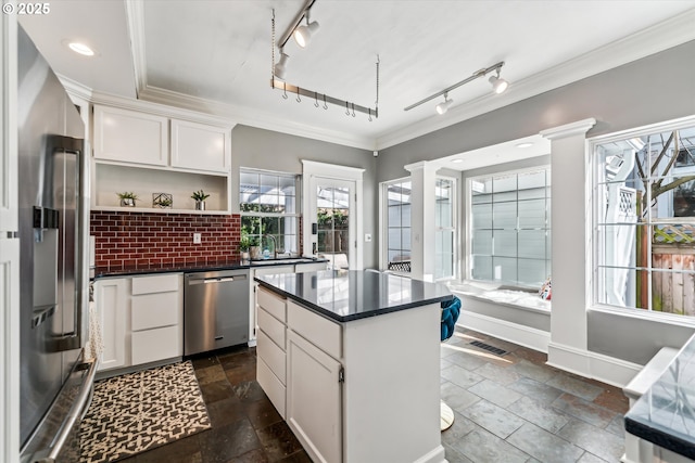 kitchen featuring stainless steel appliances, dark countertops, visible vents, and crown molding