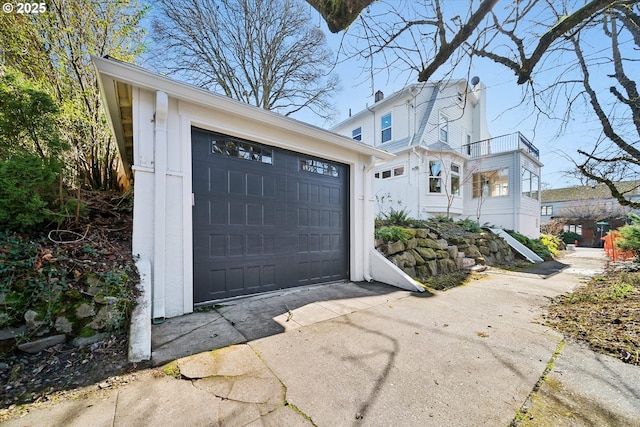 view of front facade featuring a garage, concrete driveway, and an outdoor structure