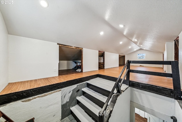 staircase with lofted ceiling and recessed lighting