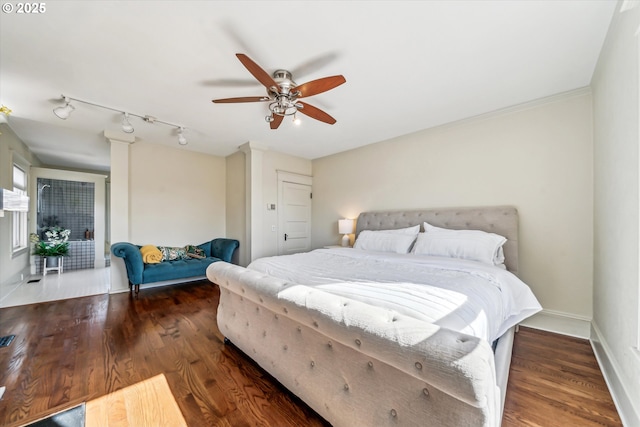 bedroom with a ceiling fan, ornate columns, baseboards, and wood finished floors