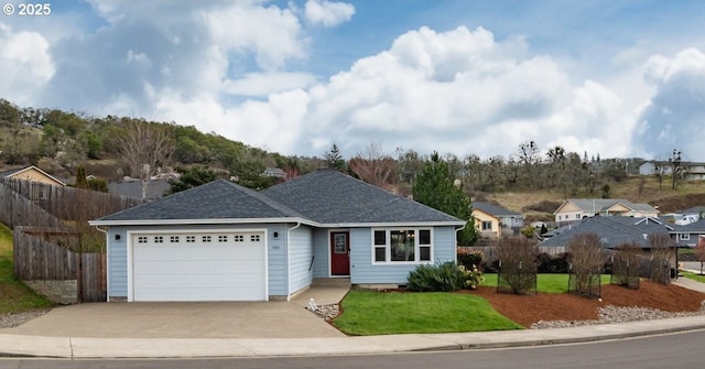 single story home featuring driveway, fence, a front yard, a shingled roof, and a garage