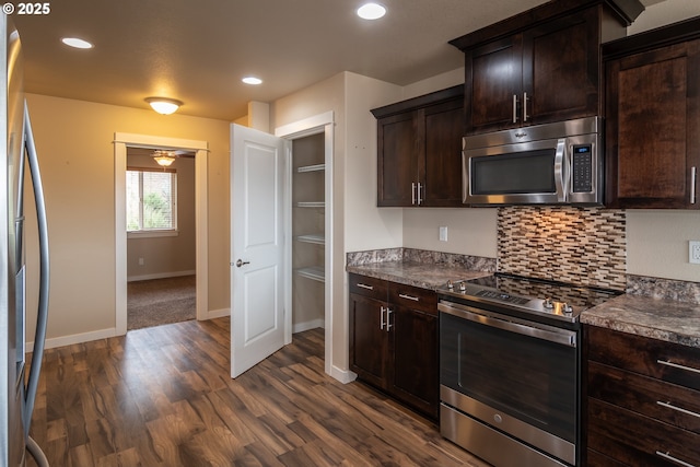 kitchen with tasteful backsplash, dark brown cabinets, baseboards, appliances with stainless steel finishes, and dark wood-style flooring