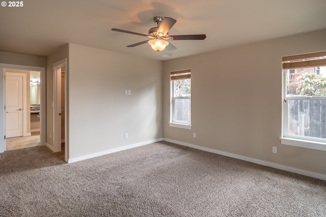 empty room with baseboards, light colored carpet, visible vents, and ceiling fan