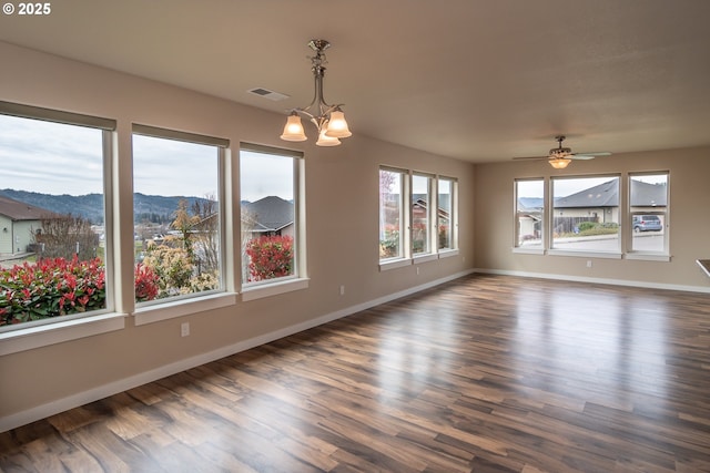 empty room featuring visible vents, baseboards, dark wood finished floors, and a mountain view