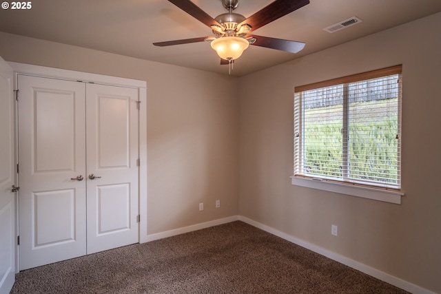 unfurnished bedroom with visible vents, a closet, carpet, baseboards, and ceiling fan