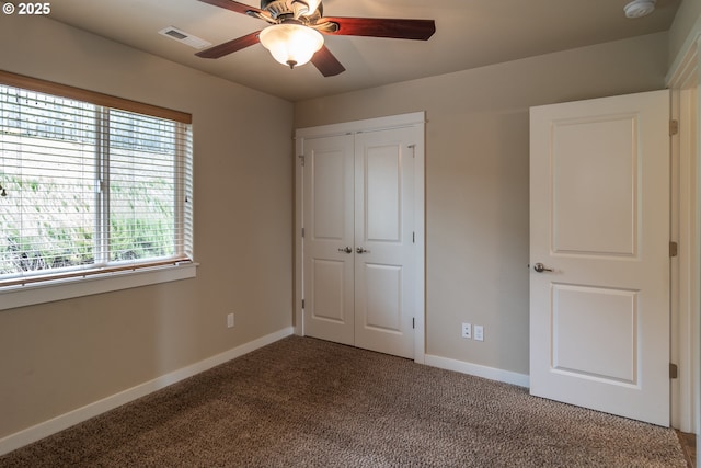 unfurnished bedroom with carpet flooring, a ceiling fan, baseboards, and a closet