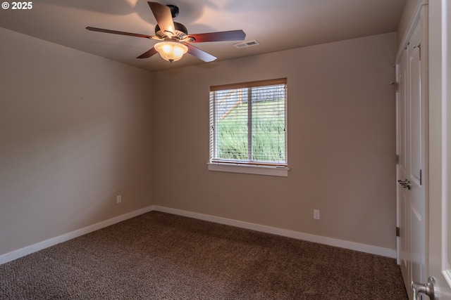 carpeted spare room with baseboards, visible vents, and ceiling fan