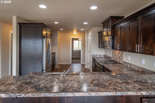 kitchen with a sink, recessed lighting, appliances with stainless steel finishes, decorative backsplash, and dark brown cabinets