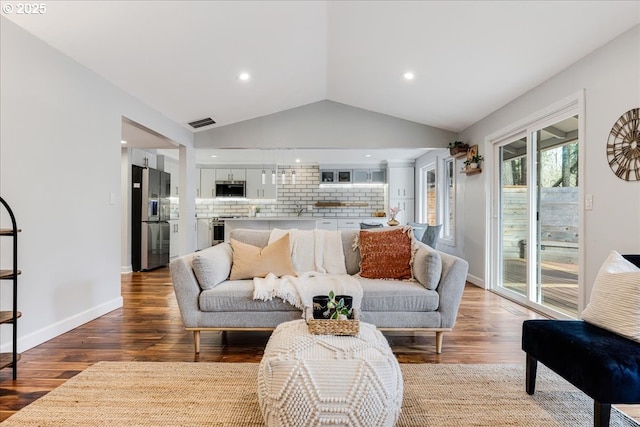 living room featuring vaulted ceiling, recessed lighting, wood finished floors, and baseboards