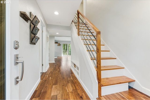 stairway with recessed lighting, baseboards, and wood finished floors