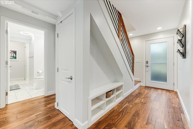 interior space with recessed lighting, baseboards, light wood finished floors, and a barn door