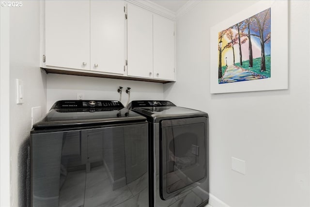 laundry area featuring washing machine and clothes dryer, cabinet space, and crown molding