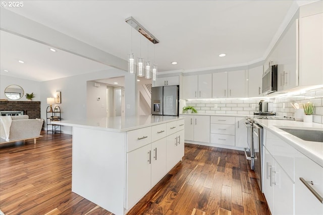 kitchen featuring appliances with stainless steel finishes, light countertops, a center island, and white cabinets