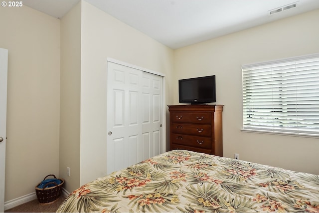 bedroom with a closet, carpet flooring, baseboards, and visible vents
