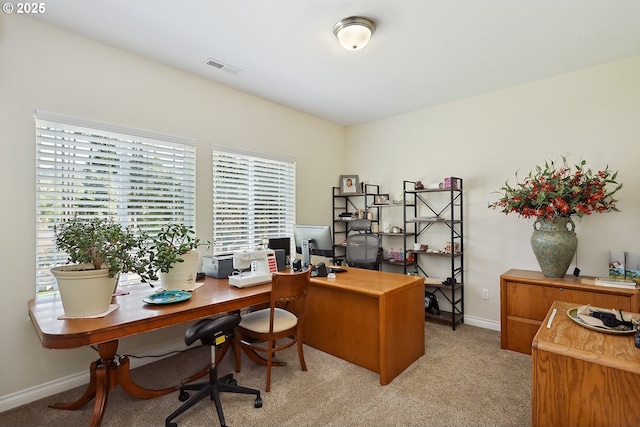 office space featuring light carpet, a healthy amount of sunlight, and visible vents