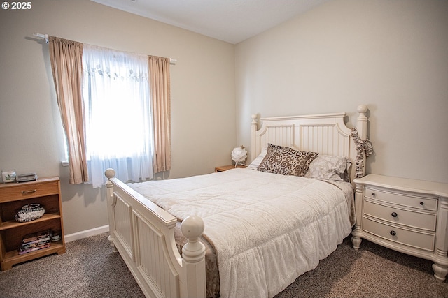 bedroom featuring dark colored carpet and baseboards