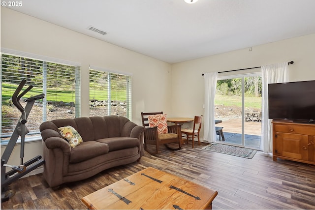 living area featuring visible vents and dark wood-style flooring