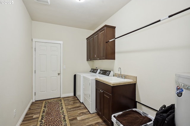 clothes washing area with baseboards, washer and dryer, dark wood-style flooring, a sink, and cabinet space