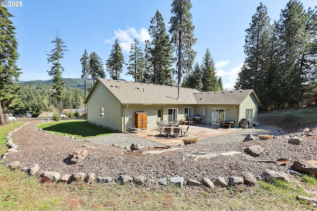 back of house with a patio and a lawn