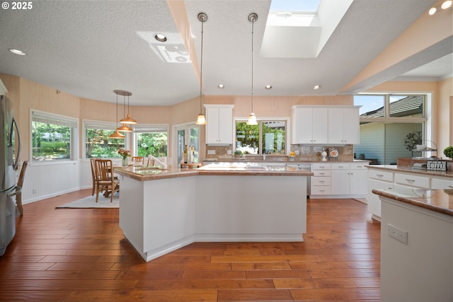1421 SE 79th Ct, Vancouver, WA 98664 - kitchen featuring a center island, hardwood / wood-style floors, a textured ceiling, white cabinetry, and recessed lighting