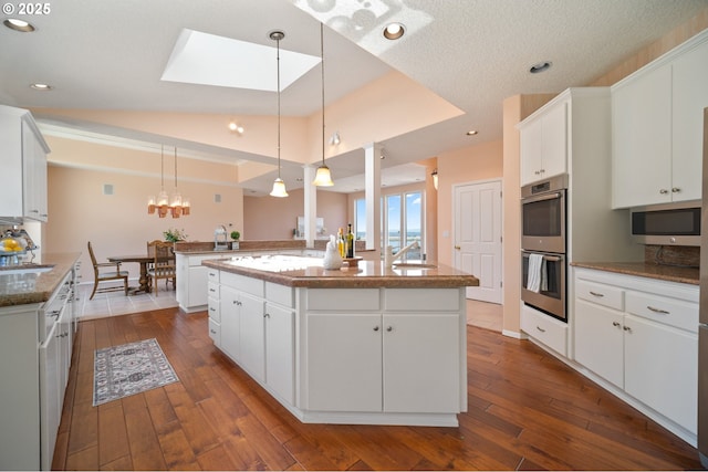1421 SE 79th Ct, Vancouver, WA 98664 - kitchen with appliances with stainless steel finishes, a center island with sink, white cabinetry, dark wood-style flooring, and recessed lighting