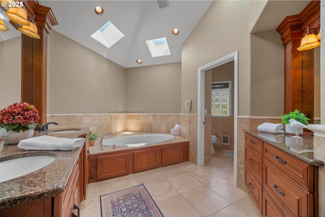 1421 SE 79th Ct, Vancouver, WA 98664 - bathroom with a skylight, double vanity, a garden tub, tile walls, and a wainscoted wall