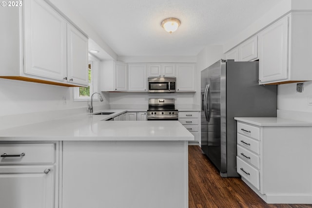14613 NE 35th St, Vancouver, WA 98682 - kitchen with a peninsula, light countertops, white cabinetry, a sink, and stainless steel appliances