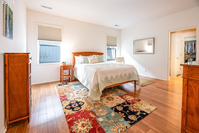 bedroom with multiple windows and light wood-type flooring