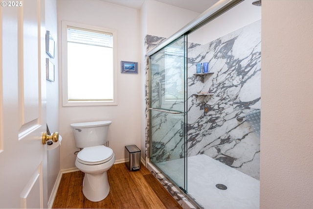 bathroom with hardwood / wood-style flooring, toilet, and walk in shower